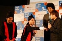 記者から「スリムクラブで映画を撮るとしたら？」と問われ、「なんでもやりますよ！アクションでも！」と、正拳突きを披露するスリムクラブ内間（中央）。