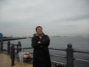 横浜の海をバックにした堤下。ベイブリッジを有効利用したデートプランを説明している。