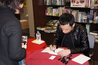 「板尾日記6」にサインをする板尾。