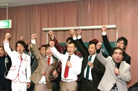 漫才協会会長の青空球児（前列右端）とともに、拳を突きあげて雄叫びをあげる一同。