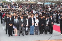 黙祷を捧げる出席者。