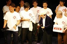 木本と沖縄旅行に行った際に買ったという思い出の詰まったループタイを出品したビーグル38能勢。この後加藤の元気いっぱいなキャラも出現。(c)松竹芸能