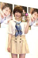 DVD「びしょ濡れレポーターおかもとまり～噛んだら濡れる、笑いと涙の凱旋帰郷～」の発売記者会見に出席したおかもとまり。背後のポスターは、水をかけられて「ほぼすっぴん」だというおかもとの顔。