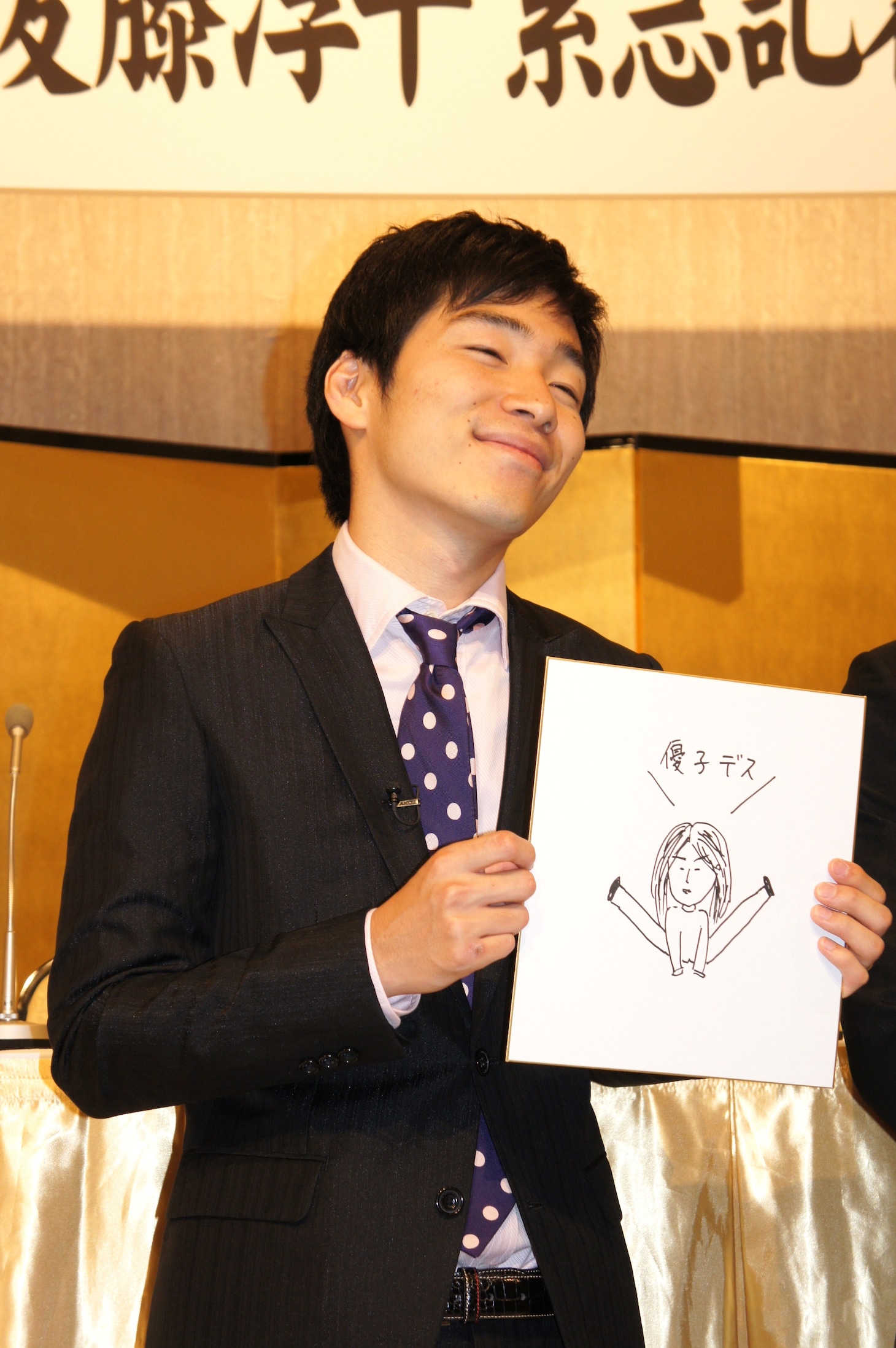 結婚記者会見を開いたジャルジャル後藤。自筆の妻の似顔絵を手に笑顔を浮かべる。