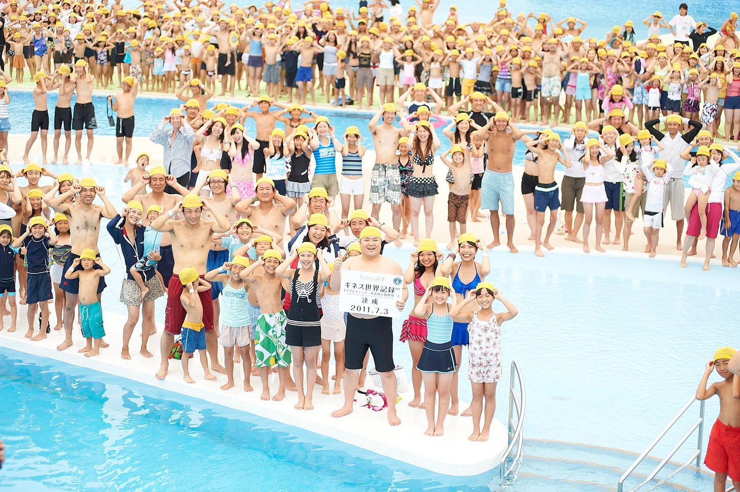 ひらパー兄さんことブラックマヨネーズ小杉と、黄色のスイムキャップをかぶって記録に一緒に挑戦した参加者たち。