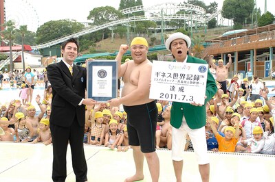 大阪・ひらかたパークにて見事「スイムキャップ一斉着用人数世界一」のギネス世界記録を達成したひらパー兄さんことブラックマヨネーズ小杉（中央）と、計測員を務めた相方・吉田（右）。