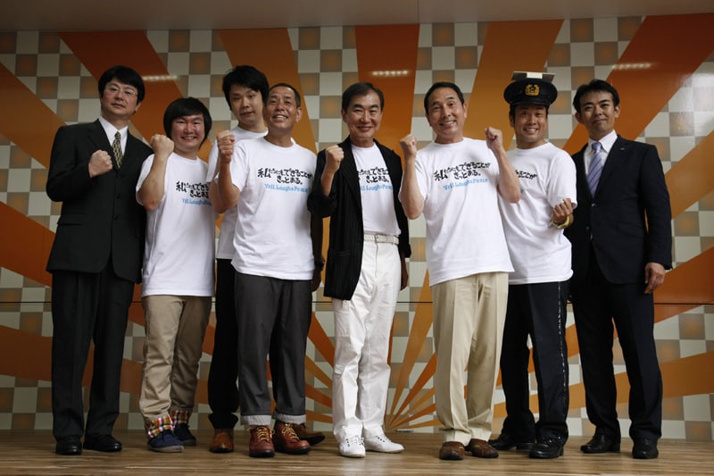 桂三枝の発案により完成した「被災地巡回トラック 移動あおぞら花月」。会見には三枝、ザ・ぼんち、かまいたち、こんばらさん、アートコーポレーション・田代憲営業部長、よしもとクリエイティブ・エージェンシー・泉正隆取締役が出席した。(c)吉本興業