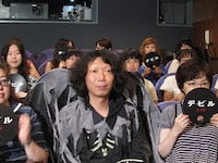 観客席に座り撮影準備を待つ家城。