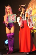 コスプレのモデルとなったキャラクターのパネルを手にする衛藤美彩と綾乃美花（左から）。