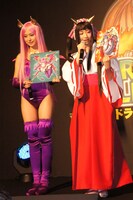 コスプレのモデルとなったキャラクターのパネルを手にする衛藤美彩と綾乃美花（左から）。