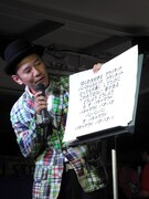 フリップを使ったネタを披露するオモロー山下。ステージ上に用意していたフリップがすべて風に飛ばされて出演順を入れ替えるというハプニングも。