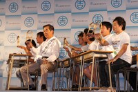 模型「紙ぶるる」を使って建物の耐震強度について学ぶ芸人たち。