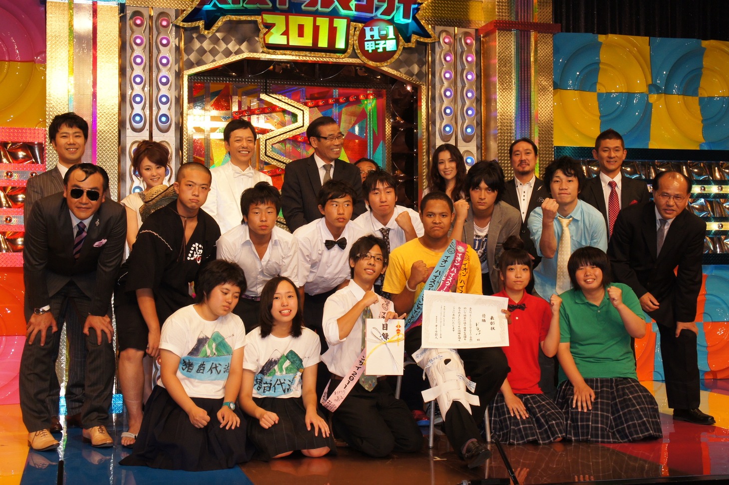 高校生漫才師ナンバーワンを決定する「イオン ハイスクールマンザイ2011 H-1甲子園」で優勝を果たしたドラッパ（前列中央）と高校生漫才師たち。オール巨人・阪神、板尾創路、藤井隆、笑い飯、たむらけんじといった芸人勢も激闘を見守った。