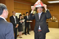 金魚ちゃんキャップを手に嬉しそうな古坂大魔王。