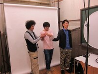 テレビジョン風ジャケットの撮影をするトータル。手にはレモンではなくある物体が。