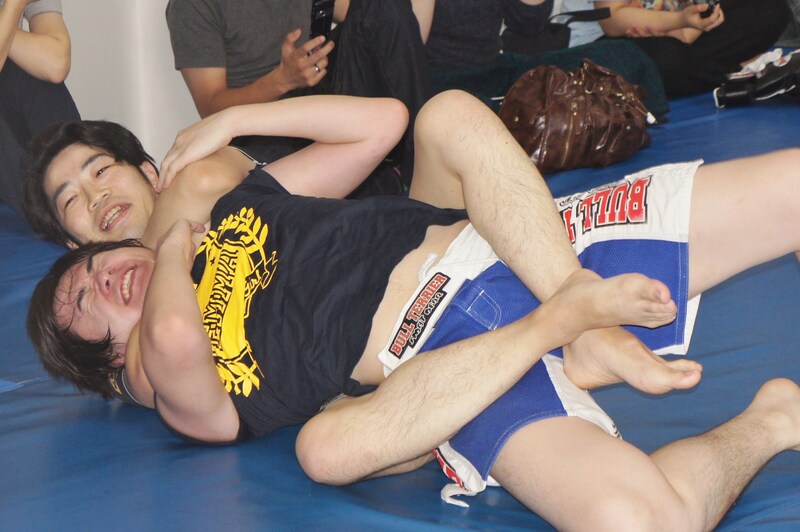 ドランクドラゴン鈴木に背後から寝技を決められる飛永。