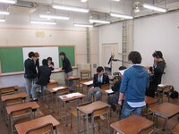 人気者の藤原先生は生徒たちか質問責め。佐藤は幼なじみの女生徒が気になる様子。