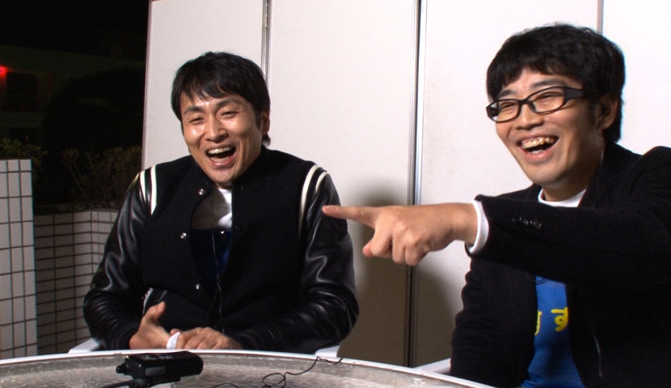 遠くから高橋の奮闘ぶりを見守るアンジャッシュ児嶋（左）とドランクドラゴン鈴木（右）。