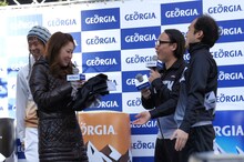 古閑美保選手（左）にエメマンジャージを贈呈するトレンディエンジェル（右）。