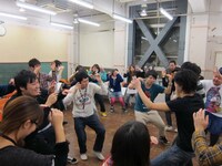 自分たちの出番まで阿波踊りを練習するチーム。江崎は基本の動きを丁寧に教えながら「スマイルね！」などと声かけ。