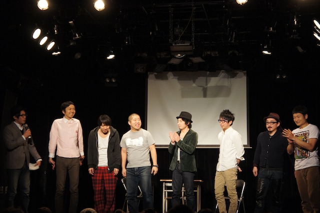 「ワタナベvsスラッシュパイル『ゲームセンター 表参道店』」の一場面。ザブングル松尾（左端）MCのもと、7名の芸人がゲーム対決を繰り広げた。