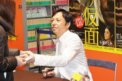 サインの後でファンと握手する板尾創路。