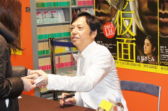 サインの後でファンと握手する板尾創路。