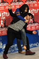 記者にコブラツイストをかけられる井上。