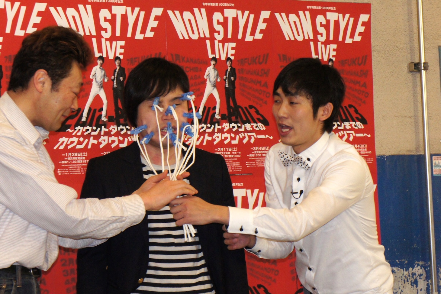 洗濯バサミを顔面に装着される井上（中央）。