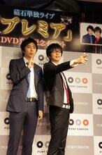 DVDのジャケットをふまえ、拳銃を構えるポーズでフォトセッションに応じる磁石。