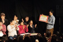 「R-1ぐらんぷり2011」優勝のニュースをあらためて掲げ、喝采を受ける佐久間一行（右端）。