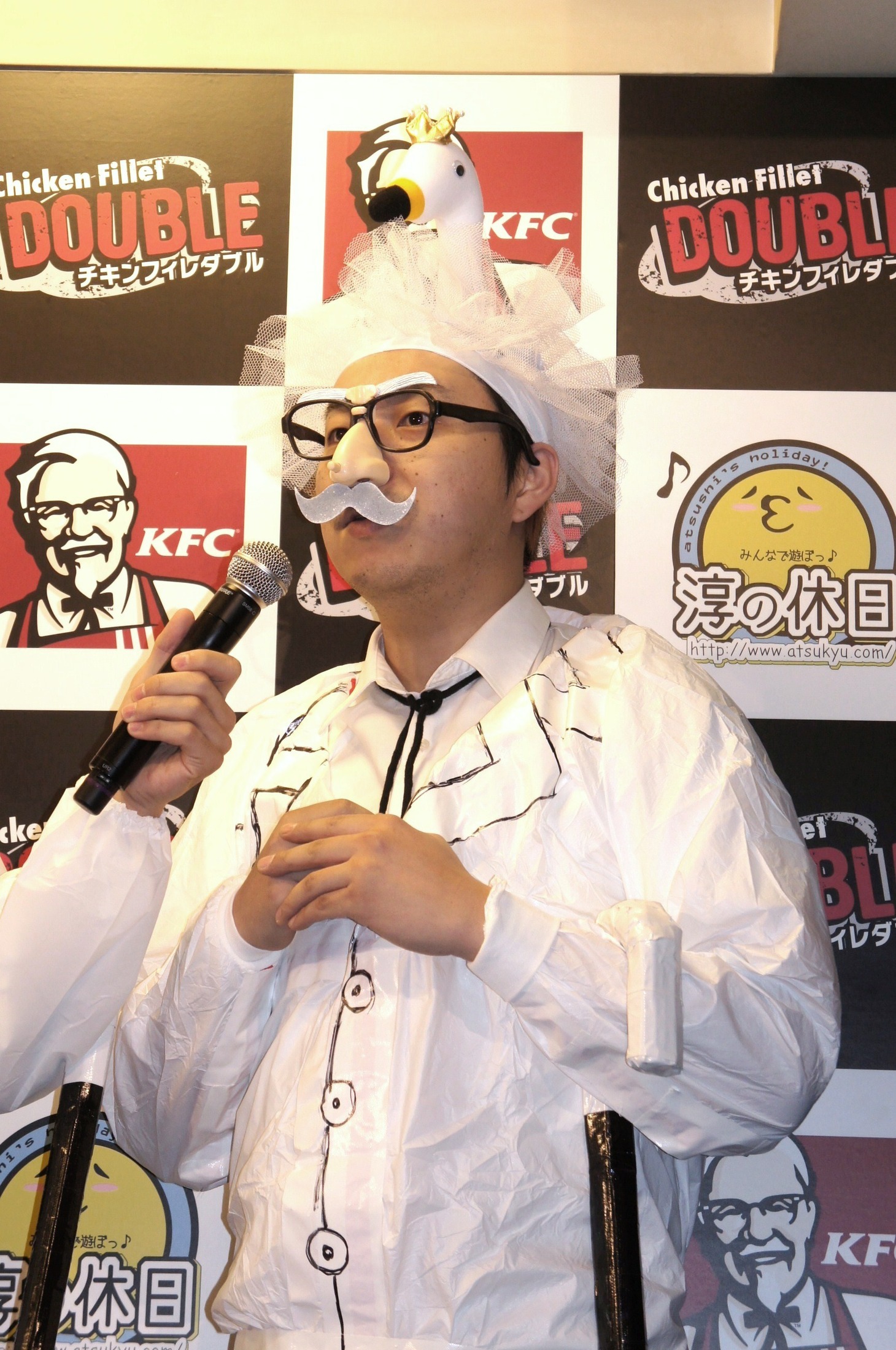 カーネル・サンダースのコスプレで、頭になぜか白鳥を乗せるニブンノゴ！大川。パーティグッズの鼻メガネを着用している。