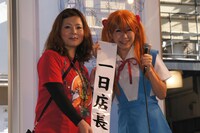 ストアの本物の店長から一日店長のタスキを手渡される稲垣（右）。