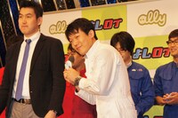 「よしログルメ隊」任命バッチを贈呈されたペナルティ・ヒデ。