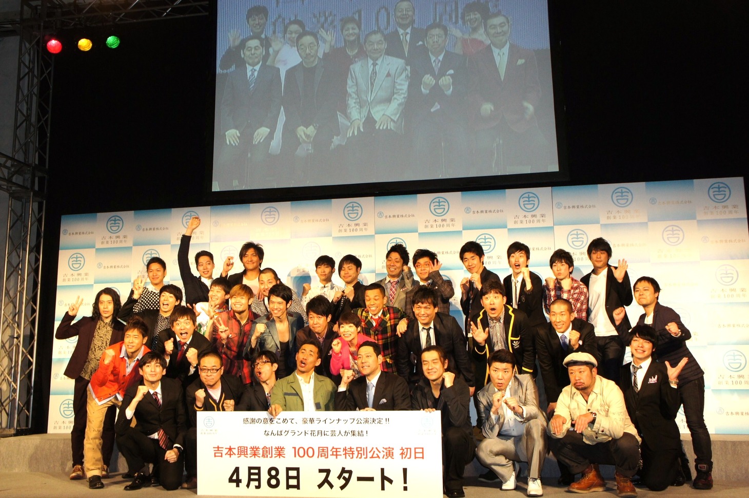 「吉本興業創業100周年特別公演初日発表会見」の出席者一同。上部スクリーンには大阪会場の様子が映し出された。