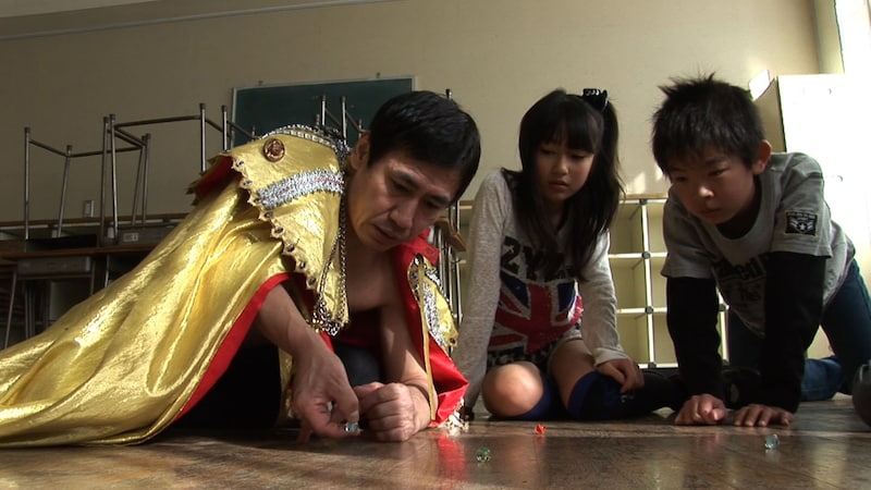 DVD「エスパー伊東の昭和の遊び方」の一場面。エスパー（左）が子供達と「昭和の遊び」を楽しむ。(c)CURIOUSCOPE