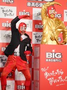 黄金のBIGマン像の前でポーズを決めるBIGマン。