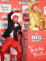 黄金のBIGマン像の前でポーズを決めるBIGマン。