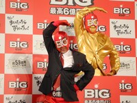 黄金のBIGマン像の前でポーズを決めるBIGマン。