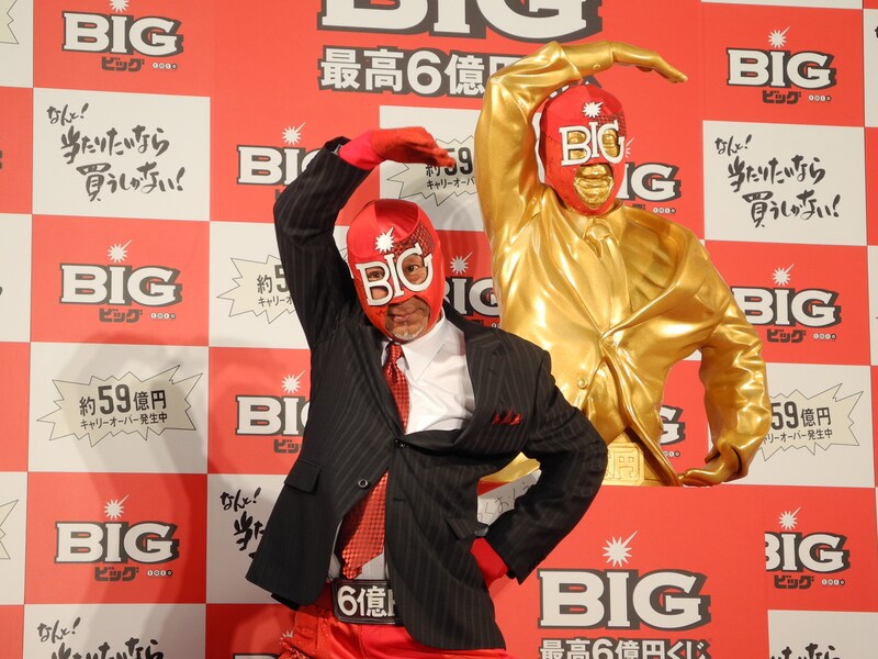 黄金のBIGマン像の前でポーズを決めるBIGマン。