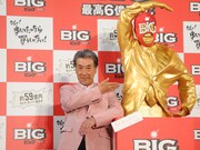 黄金のBIGマン像の前でポーズを決める高田純次。