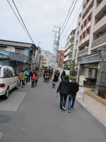 目的地もわからず住宅街を歩くツアー参加者たち。