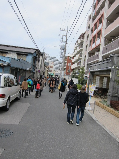 目的地もわからず住宅街を歩くツアー参加者たち。