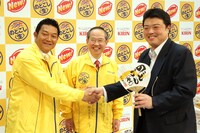 一般客へ特製うちわを配布する山口智充（左）。