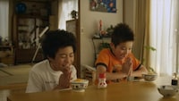 CMの一場面。たまごかけご飯を食べる、子供の頃の「宇宙兄弟」。