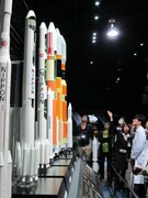 白衣で説明を聞く菊地。