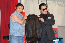 「ワイルドPR隊長」の証として、レザーのジャケットをテル（右）に手渡されるスギちゃん（左）。