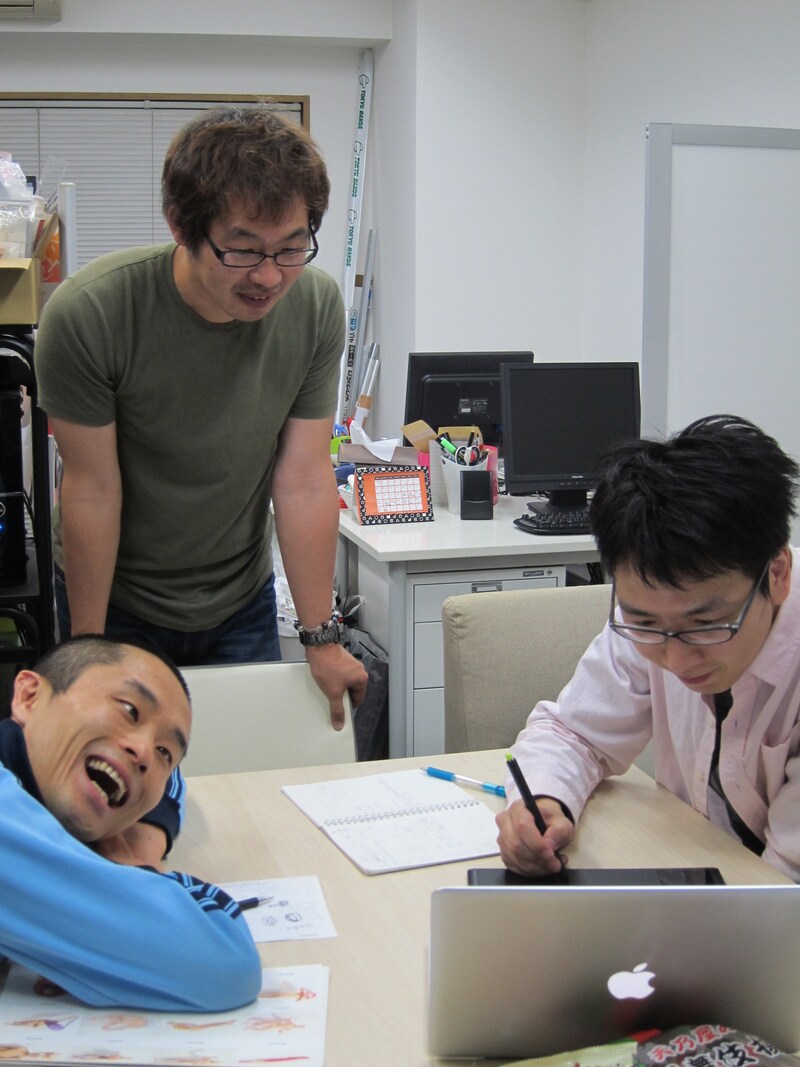 6月12日（火）より、東京・下北沢HIBOU HIBOUにて行われる「ハブ展」の打ち合わせをするBコース・ハブ、河村正和カメラマン、デザイン担当ノンスモーキン菊池。