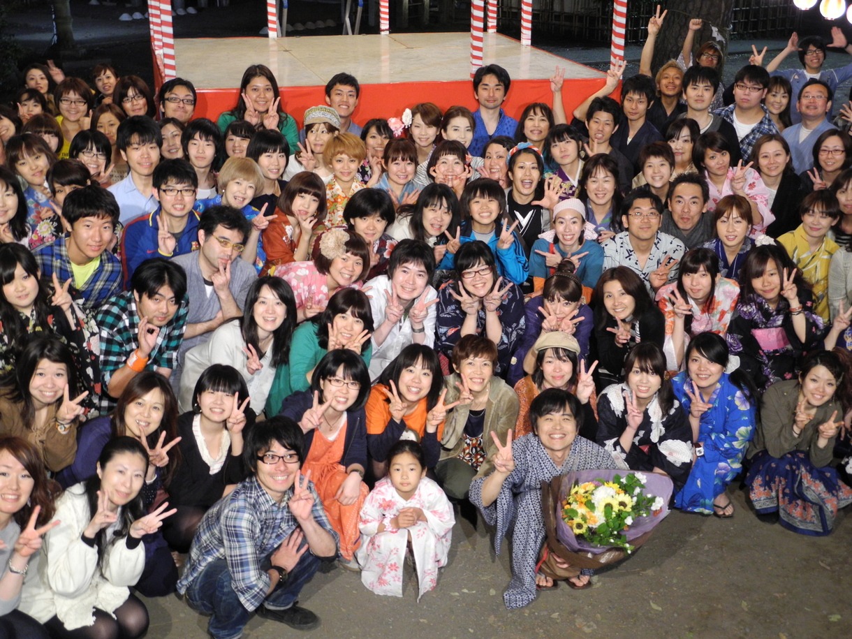 昨日5月13日にクランクアップを迎えた映画「バカリズム THE MOVIE」。花束を抱え、集まったエキストラとともに笑顔でピースするバカリズム。