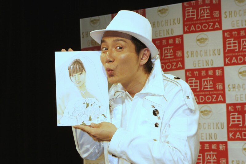 入籍会見を開いた「収納王子コジマジック」ことオーケイ小島。アメリカザリガニ平井が描いた妻の似顔絵を手にフォトセッションに応じる。